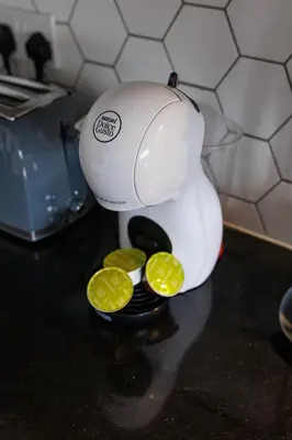 a juicer with two lemon slices in it on a counter at Flatzy - Prime City Apartment with Free Parking & Ping Pong Table in Liverpool