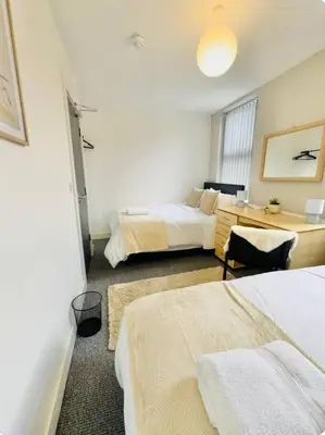 a hotel room with two beds and a desk at Room 4 Shared House in L6 in Liverpool