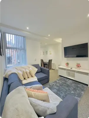 a living room with a blue couch and a tv at Room 4 Shared House in L6 in Liverpool