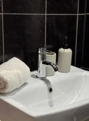 a bathroom sink with a towel and a soap dispenser at Room 5 Shared House in L6 in Liverpool