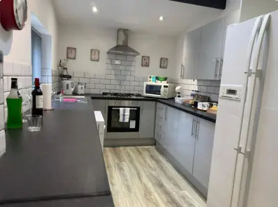 a kitchen with white appliances and a black counter top at Room 6 Shared House in L6 in Liverpool