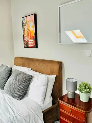 a bedroom with a bed and a night stand with a nightstand at Room 6 Shared House in L6 in Liverpool