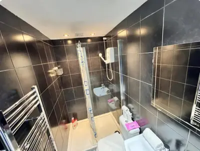 a bathroom with a shower and a toilet and a mirror at Room 6 Shared House in L6 in Liverpool