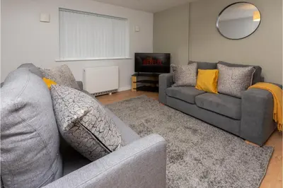 a living room with two couches and a television at Central 3 Bedroom Flat w Parking in Liverpool