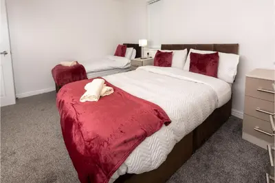 a bedroom with two beds with red and white sheets at Central 3 Bedroom Flat w Parking in Liverpool