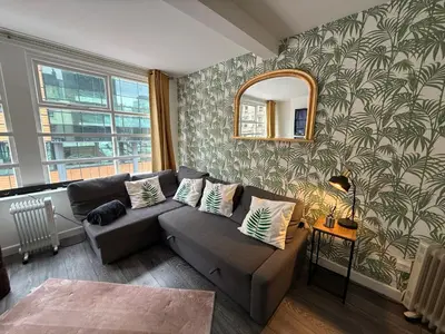 a living room with a couch and a mirror at 61 Moorfields city centre apartment sleeps 10 in Liverpool