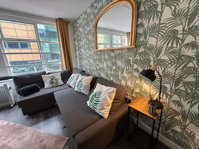 a living room with a couch and a large window at 61 Moorfields city centre apartment sleeps 10 in Liverpool