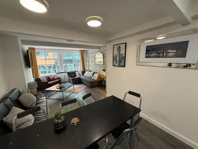 a living room with a black table and chairs at 61 Moorfields city centre apartment sleeps 10 in Liverpool