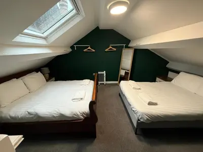 two beds in a room with green walls at 61 Moorfields city centre apartment sleeps 10 in Liverpool