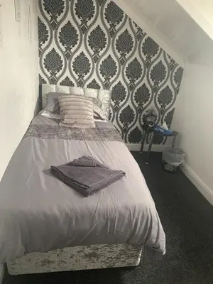 a bedroom with a bed with a black and white wallpaper at The Butterfly Hotel in Blackpool