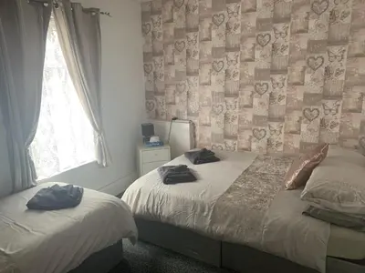 a bedroom with two beds and a window at The Butterfly Hotel in Blackpool