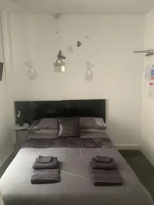 a bedroom with a large bed with three towels on it at The Butterfly Hotel in Blackpool