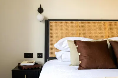 a bedroom with a white bed with a wooden headboard at Domain Boutique Rooms in Lancaster