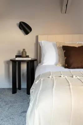 a bedroom with a bed and a table with a lamp at Domain Boutique Rooms in Lancaster