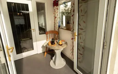 a small table and a chair in a room at Smithy Cottage in Heysham