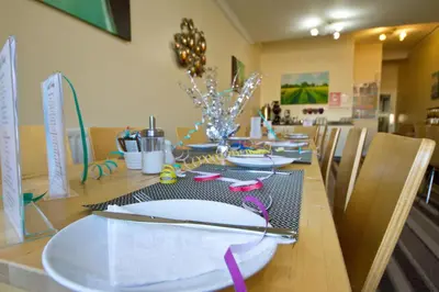 a dining room table with white plates on it at Rossall Guest House Blackpool - Ideal For Families & Couples in Blackpool