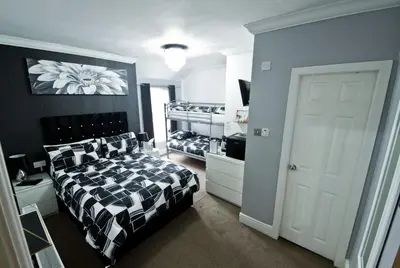 a bedroom with a bed and two bunk beds at Rossall Guest House Blackpool - Ideal For Families & Couples in Blackpool