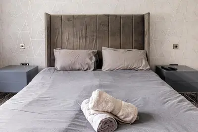 a bed with two pillows on it with two tables at Lux nights away in Cleveleys