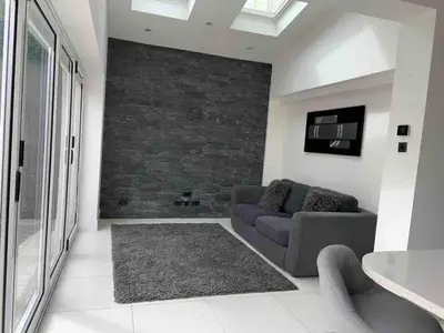 a living room with a couch and a brick wall at Lux nights away in Cleveleys