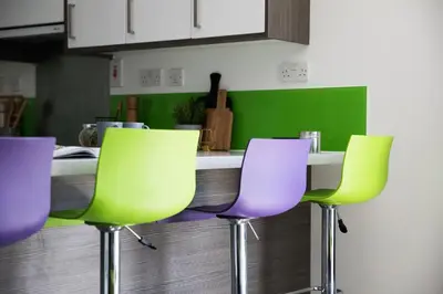 a kitchen with three green and purple chairs at Prospect Point in Liverpool in Liverpool