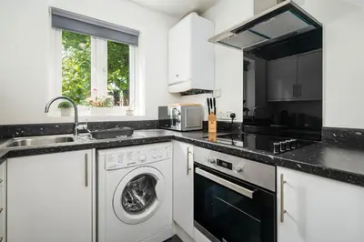 a kitchen with a washing machine and a sink at The Acorn Nook - Central Stay in Liverpool