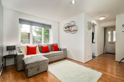 a living room with a gray couch and red pillows at The Acorn Nook - Central Stay in Liverpool