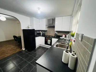 a kitchen with a sink and a black refrigerator at Liberty Guest House in Liverpool