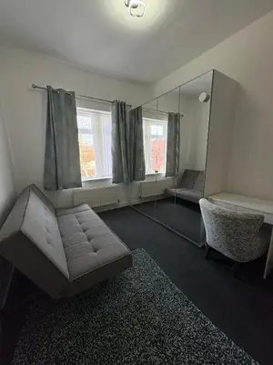 a living room with a couch and a mirror at Liberty Guest House in Liverpool