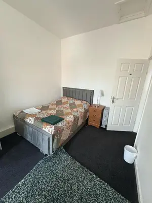 a small bedroom with a bed and a door at Liberty Guest House in Liverpool