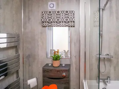 a bathroom with a shower and a toilet and a window at Coniston View Lodge in Carnforth