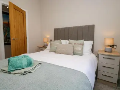 a bedroom with a large white bed and two lamps at Coniston View Lodge in Carnforth