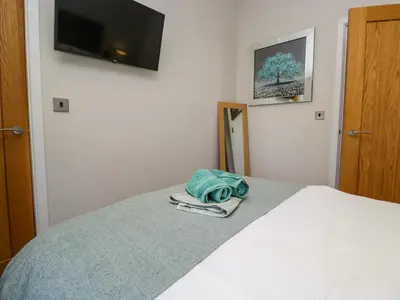 a bedroom with a bed with a tv on the wall at Coniston View Lodge in Carnforth