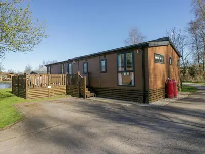 a small wooden house with a red fire hydrant in front of it at Coniston View Lodge in Carnforth