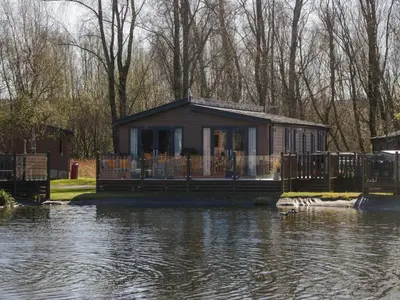 a house sitting on the edge of a river at Coniston View Lodge in Carnforth