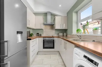 a kitchen with white cabinets and a window at Bolton Retreat Modern 3BR Home Pool Table & Parking Sleeps 6 in Bolton