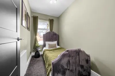 a small bedroom with a bed and a window at Bolton Retreat Modern 3BR Home Pool Table & Parking Sleeps 6 in Bolton
