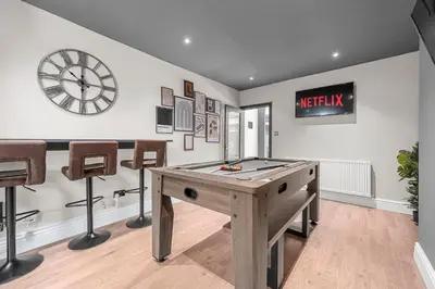 a room with a ping pong table and a clock at Bolton Retreat Modern 3BR Home Pool Table & Parking Sleeps 6 in Bolton