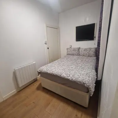 a bedroom with a bed and a television on the wall at Ground Floor Holiday flat in Blackpool