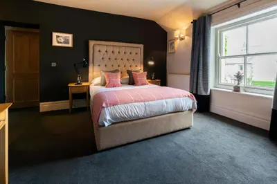 a bedroom with a bed and a large window at Derby Arms in Longridge