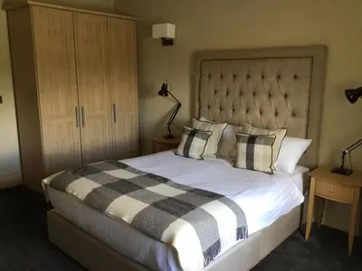 a bedroom with a large bed with a checkered blanket at Derby Arms in Longridge