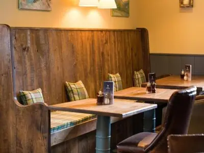 a restaurant with two wooden tables and chairs at Derby Arms in Longridge