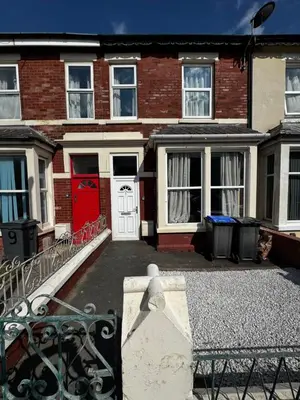 a brick house with a red door and a gate at Harmony House - Close to Blackpool FC - Excellent Transport Links - Sleeps up to 6 in Blackpool