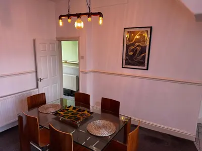 a dining room with a table and chairs and a painting at Harmony House - Close to Blackpool FC - Excellent Transport Links - Sleeps up to 6 in Blackpool