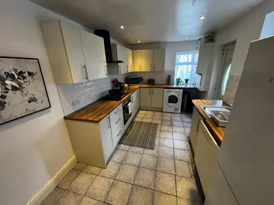 a kitchen with white cabinets and a tile floor at Harmony House - Close to Blackpool FC - Excellent Transport Links - Sleeps up to 6 in Blackpool