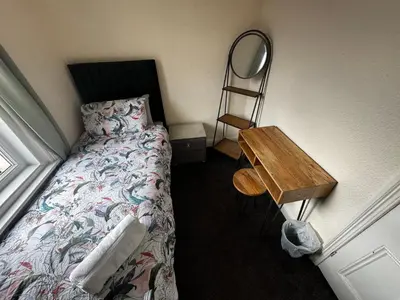 a bedroom with a bed and a table and a mirror at Harmony House - Close to Blackpool FC - Excellent Transport Links - Sleeps up to 6 in Blackpool