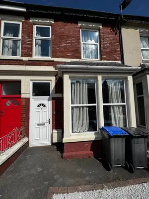 a red brick house with a white door and two trash cans at Harmony House - Close to Blackpool FC - Excellent Transport Links - Sleeps up to 6 in Blackpool
