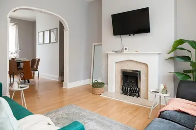 a living room with a fireplace with a tv on the wall at CLOSe in Liverpool
