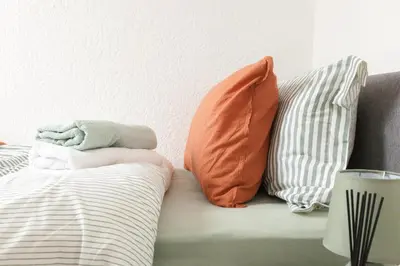 a couch with pillows on it next to a wall at CLOSe in Liverpool