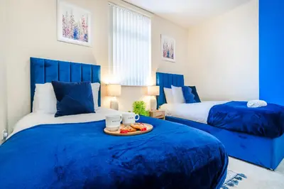 a blue bedroom with two beds and a tray of food at Long-Term Work Stay 20 Percent OFF Fully Equipped & Central Location in Horwich