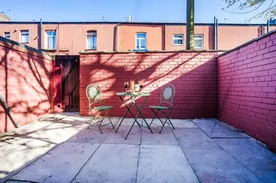 a patio with two chairs and a table against a brick wall at Long-Term Work Stay 20 Percent OFF Fully Equipped & Central Location in Horwich